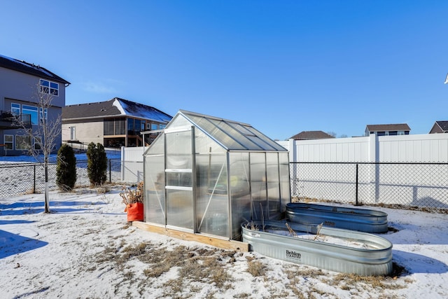 snow covered structure featuring an exterior structure, fence, and an outdoor structure