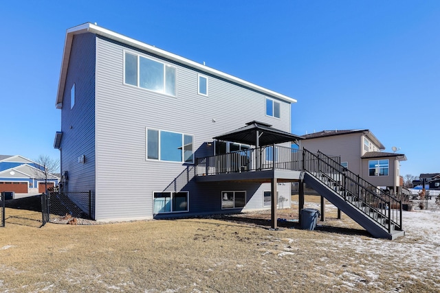 rear view of house with fence, stairway, and a wooden deck