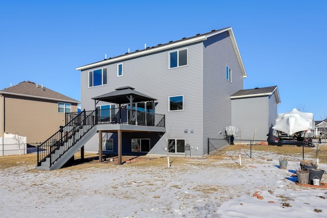 rear view of property featuring stairway, fence, and a wooden deck