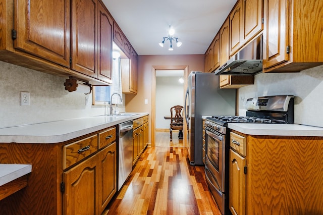 kitchen featuring sink, backsplash, light hardwood / wood-style flooring, and stainless steel appliances