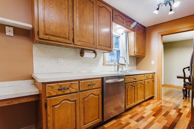 kitchen with sink, dishwasher, tasteful backsplash, and light hardwood / wood-style flooring