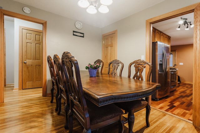 dining space featuring an inviting chandelier and light hardwood / wood-style flooring