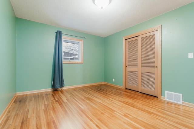 unfurnished bedroom with hardwood / wood-style floors and a closet