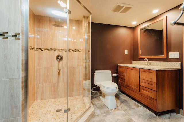 bathroom with toilet, a shower with shower door, and vanity