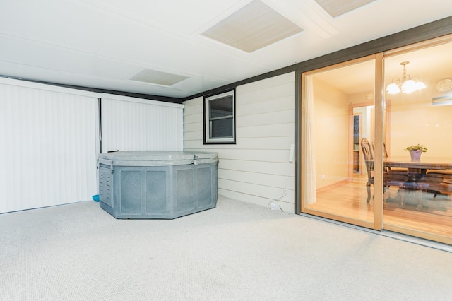 basement with a chandelier and carpet flooring