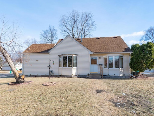 view of front of property with a front yard and central air condition unit