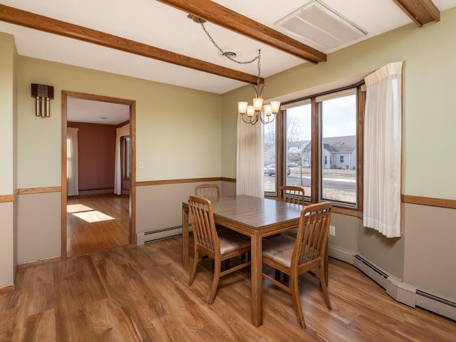 dining room featuring beam ceiling, a baseboard radiator, light wood-type flooring, and a chandelier