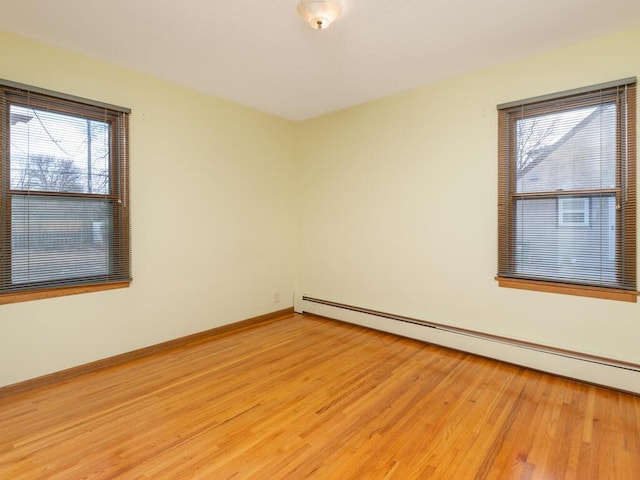 spare room featuring a baseboard radiator and light hardwood / wood-style flooring