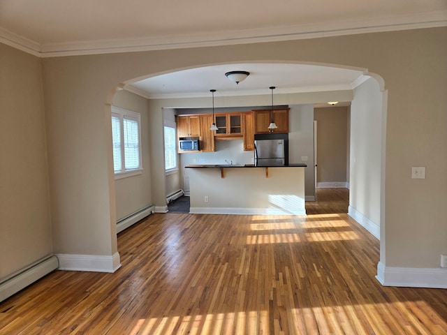 kitchen with decorative light fixtures, a baseboard radiator, dark wood-type flooring, and appliances with stainless steel finishes