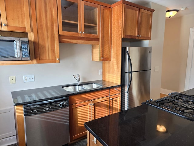 kitchen with dark stone countertops, sink, and stainless steel appliances