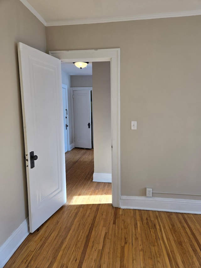 unfurnished room featuring ornamental molding and light hardwood / wood-style floors