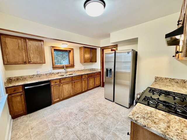 kitchen with sink, dishwasher, light stone counters, and stainless steel refrigerator with ice dispenser