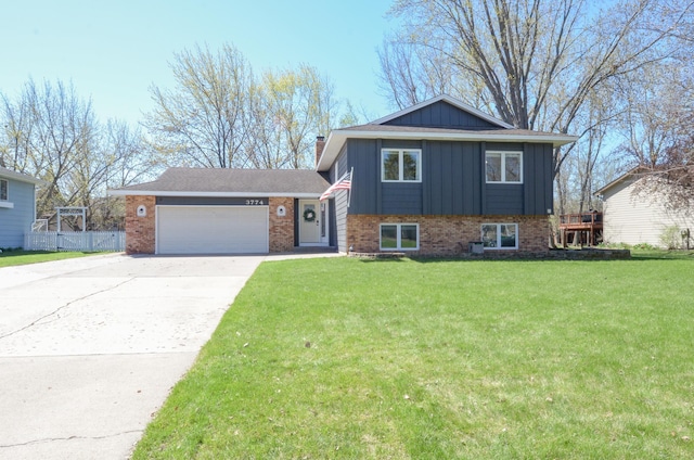 split level home with a front lawn, brick siding, a garage, board and batten siding, and concrete driveway