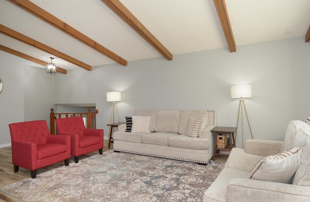 living area with baseboards, lofted ceiling with beams, and wood finished floors