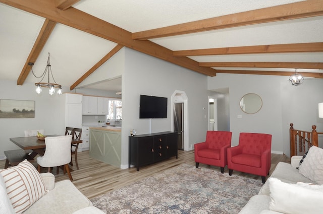 living area with vaulted ceiling with beams, arched walkways, and light wood finished floors