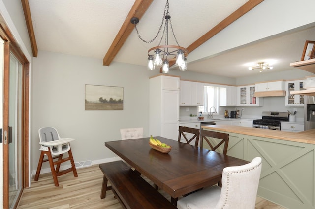 dining room with baseboards, lofted ceiling with beams, light wood-type flooring, and a notable chandelier