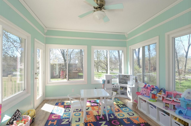 sunroom featuring crown molding and wood finished floors