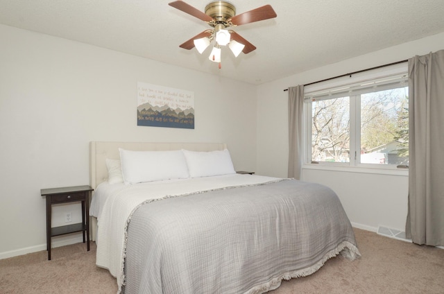 carpeted bedroom featuring baseboards, a ceiling fan, and visible vents