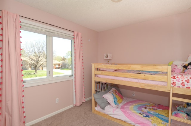 bedroom with baseboards, carpet, and a textured ceiling