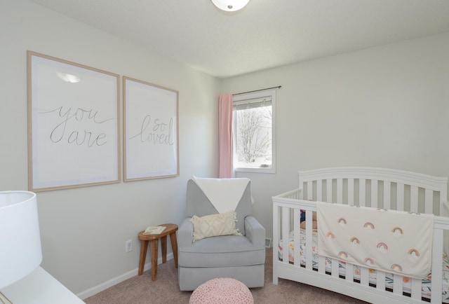 bedroom featuring baseboards, carpet, and a crib