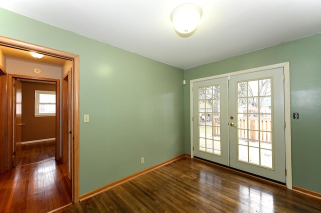 spare room featuring dark hardwood / wood-style flooring and french doors