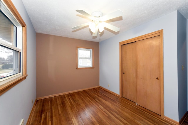 unfurnished bedroom with hardwood / wood-style flooring, ceiling fan, a textured ceiling, and a closet