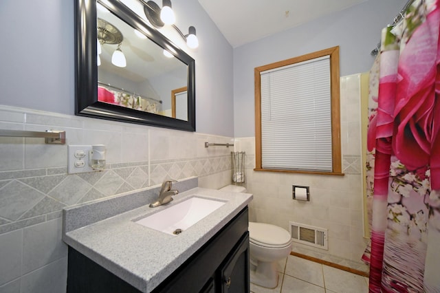 bathroom featuring tile patterned flooring, tile walls, vanity, curtained shower, and toilet