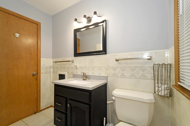 bathroom with tile patterned floors, toilet, vanity, and tile walls