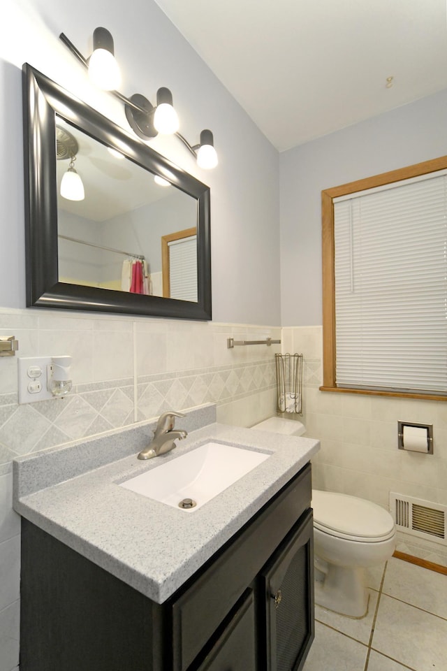 bathroom featuring tile walls, vanity, a shower with curtain, tile patterned floors, and toilet