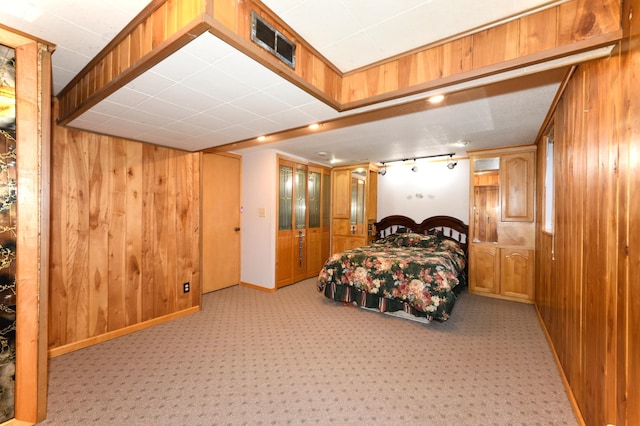 bedroom featuring light colored carpet and wood walls