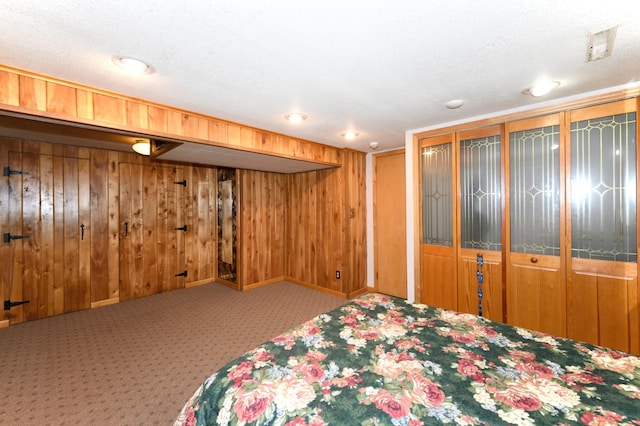 unfurnished bedroom featuring carpet, a textured ceiling, and wood walls