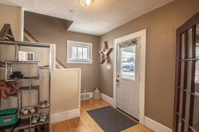 entryway with hardwood / wood-style floors and a textured ceiling