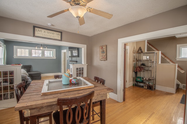 dining room with plenty of natural light, a textured ceiling, and light hardwood / wood-style floors