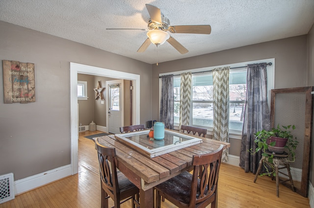 dining space featuring ceiling fan, a textured ceiling, and light hardwood / wood-style floors