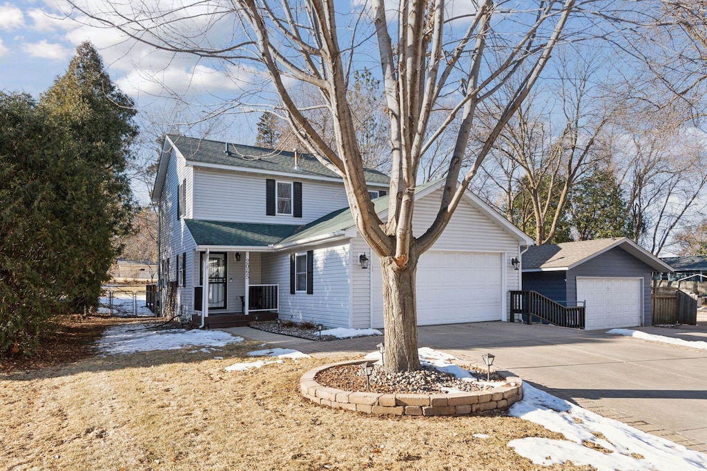 front facade with a garage, an outdoor structure, and central AC unit