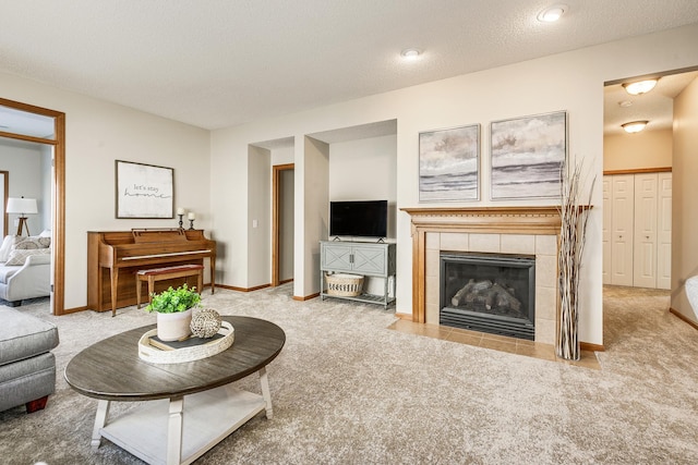 living room with light carpet, a tile fireplace, and a textured ceiling