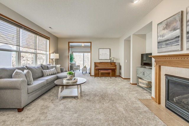 living room with light carpet, a textured ceiling, and a fireplace