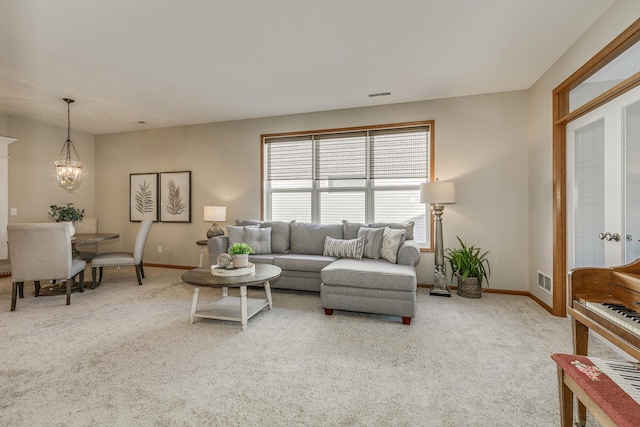 living room featuring carpet flooring and a notable chandelier