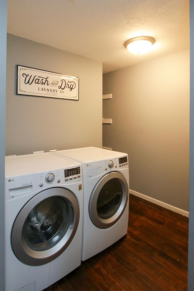 laundry area featuring separate washer and dryer, a textured ceiling, and dark hardwood / wood-style flooring