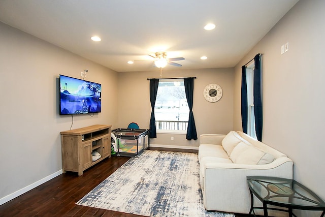 living room featuring dark wood-type flooring and ceiling fan