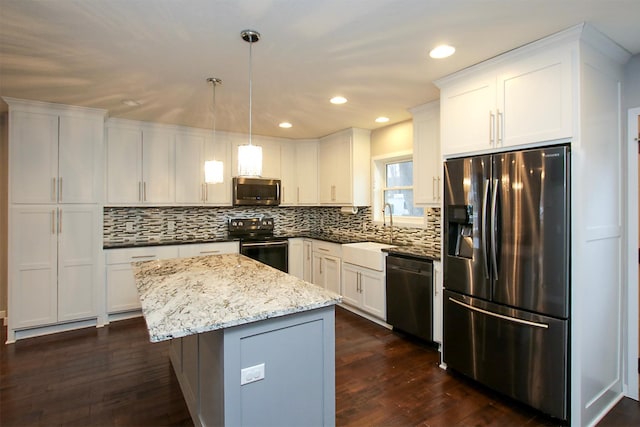 kitchen featuring sink, white cabinetry, a kitchen island, pendant lighting, and black appliances