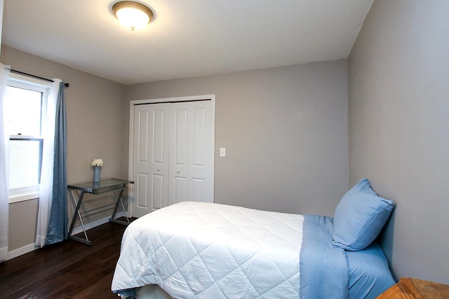 bedroom with dark hardwood / wood-style floors and a closet