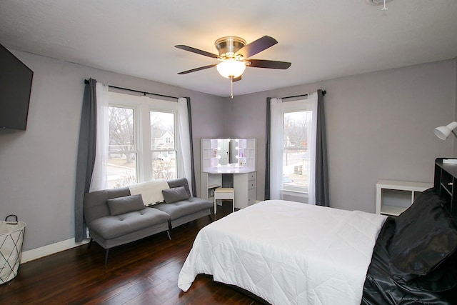 bedroom with multiple windows, dark hardwood / wood-style floors, and ceiling fan