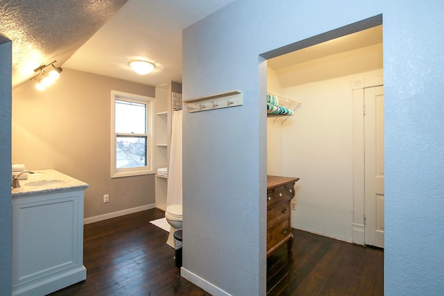 hall featuring dark hardwood / wood-style floors, sink, and a textured ceiling