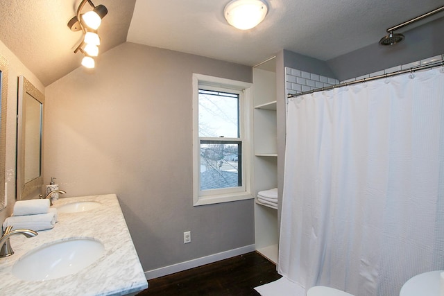 bathroom featuring toilet, vaulted ceiling, a textured ceiling, vanity, and hardwood / wood-style flooring