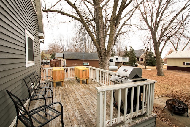 deck with a grill and a fire pit