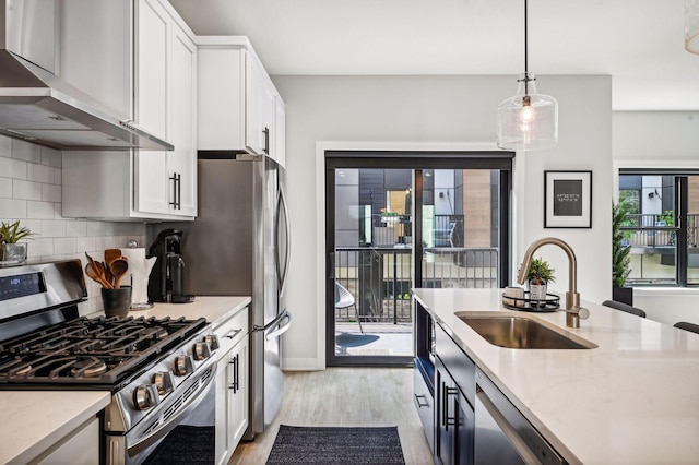 kitchen with white cabinetry, sink, wall chimney exhaust hood, and appliances with stainless steel finishes