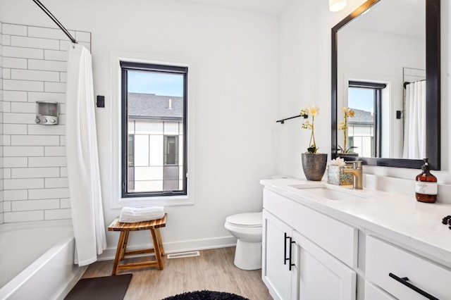 full bathroom with hardwood / wood-style flooring, vanity, toilet, and shower / bath combination with curtain