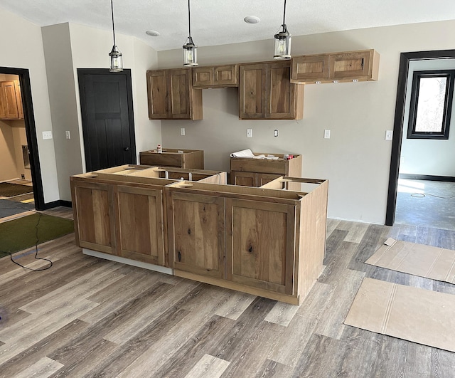kitchen featuring light wood-type flooring, pendant lighting, vaulted ceiling, and a center island