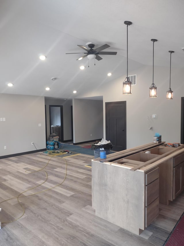 kitchen featuring visible vents, pendant lighting, lofted ceiling, light wood-style floors, and a ceiling fan